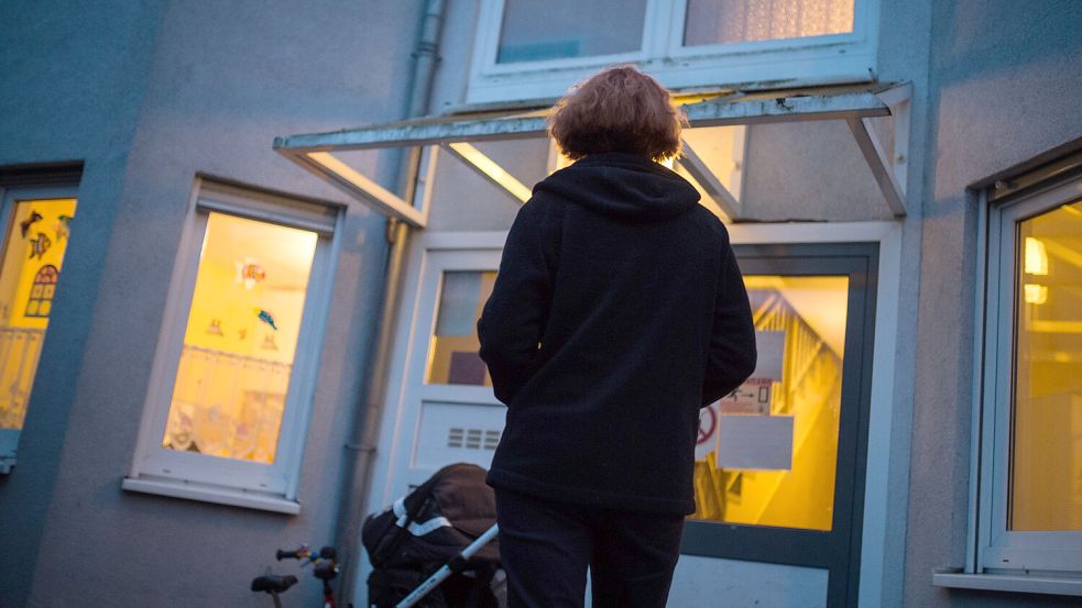 Eine Frau steht vor einem Frauenhaus. Foto: Sophia Kembowski/dpa