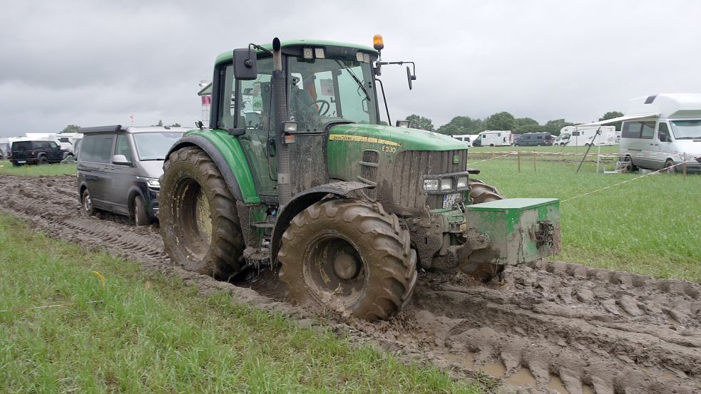 Auf dem Festivalgelände in Wacken werden wegen des aufgeweichten Bodens jede Menge Autos und Wohnmobile von Traktoren abgeschleppt. Die Landmaschinen kommen teilweise von Lohnunternehmen und teilweise von Bauernhöfen aus der Region. Foto: Marie Gloe