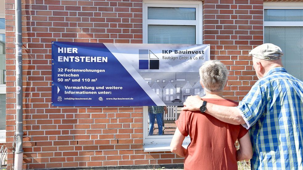 Immer wieder bleiben Spaziergänger stehen und betrachten das neue Plakat, welches an der Fassade des ehemaligen Seniorenhuus‘ in Greetsiel prangt. Hier sollen künftig Ferienwohnungen entstehen. Foto: Wagenaar