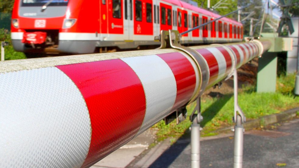 Trotz geschlossener Schranken und sich nahendem Zug hat ein Mann sein Rad über einen Bahnübergang geschoben. Foto: imago stock&people