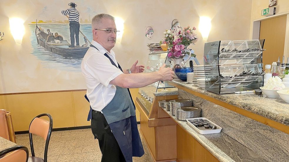 Eiscafé-Inhaber Angelo Sossai demonstriert, wie er den Tatverdächtigen vor dem Tresen seines Lokals mit beiden Armen packte und festhielt. Foto: Schuurman