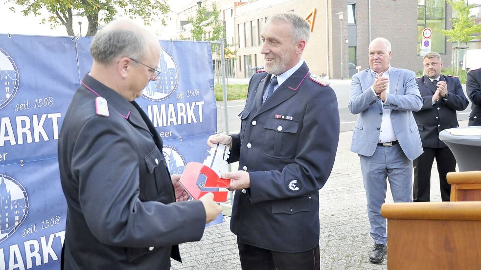 Stadtbrandmeister Jan Doosje übergab dem ehemaligen Ortsbrandmeister von Leer, Clemens Ressmann, den symbolischen Schlüssel für die Drehleiter. Ressmann hatte sich für die Anschaffung eingesetzt. Foto: Wolters