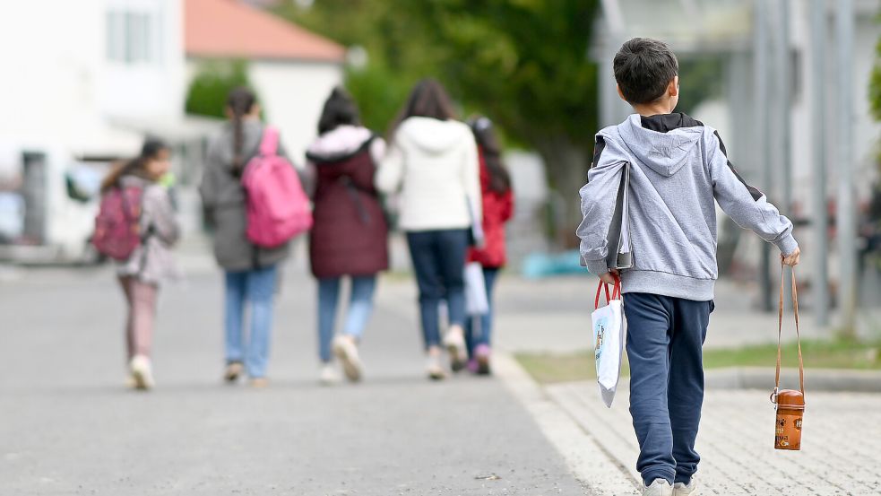 Flüchtlinge gehen in der Landesaufnahmebehörde Niedersachsen am Standort Grenzdurchgangslager Friedland an Unterkünften vorbei. Die CDU in Niedersachsen fordert in der Flüchtlings- und Migrationspolitik eine härtere Gangart. Foto: Swen Pförtner/dpa