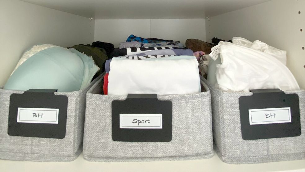 Beim „File Folding" werden T-Shirts (Mitte) ein weiteres Mal gefaltet und passen so aufrecht in eine Box wie diese. Ganz wichtig, sagt der Profi: Alles sollte beschriftet sein. Foto: SHE – Svenjas Home Edit