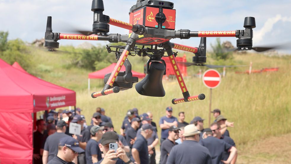 Eine Drohne der Feuerwehr mit Wärmebildkamera und Lautsprecher fliegt während einer Feuerwehrübung über einem Übungsgelände der Bundeswehr. In der Gemeinde Krummhörn wird über die Anschaffung einer Drohne für die Feuerwehr diskutiert. Symbolfoto: Karl-Josef Hildenbrand/dpa