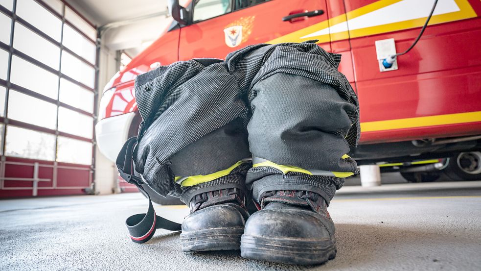 Schuhe und Overall stehen in der Garage einer Freiwilligen Feuerwehr. In der Gemeinde Krummhörn sind Neubauten für die Feuerwehr geplant. Symbolfoto: Frank Rumpenhorst/dpa