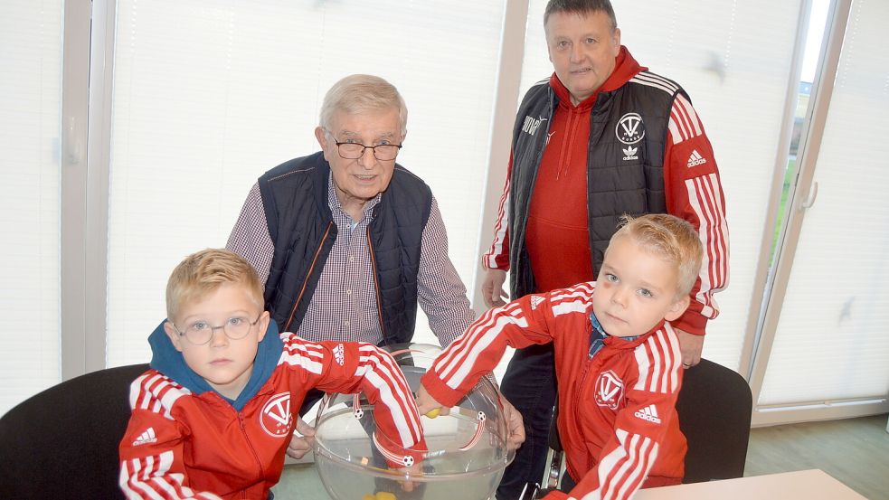 Jenke Girod (links) und Heiko Geerdes (rechts) nahmen die Gruppenauslosung für vor. Im Hintergrund beobachten Johann Schön (links, Ehrenmitglied vom Fußballkreis Ostfriesland) und Andreas Stock (rechts/stv. Fußballobmann TV Bunde) die Auslosung. Foto: Weers