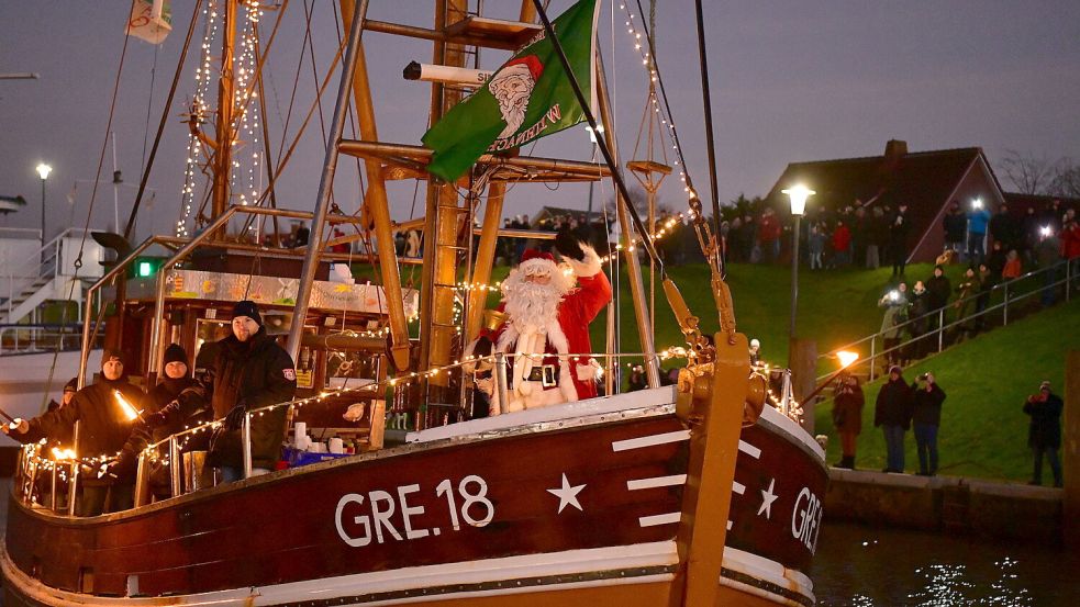 Winkend und die Glocke schlagend: So kam der Weihnachtsmann am Sonntag in Greetsiel an. Wie es sich seit mehr als zwei Jahrzehnten gehört, wurde er mit dem Kutter abgeholt. Foto: Wagenaar