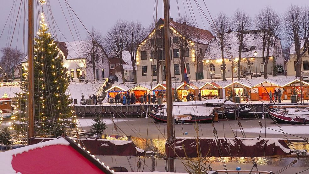 Der Wintermarkt zeichnet sich durch Charme und Atmosphäre aus. Die Hütten stehen vor den erleuchteten Fassaden der historischen Gebäude rund um den Museumshafen. Foto: Nordseebad Carolinensiel-Harlesiel GmbH