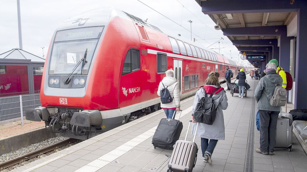 Touristen laufen mit Rollkoffern am Bahnhof Norddeich-Mole entlang: Welche Züge sie ab Mittwoch erreichen können, ist wegen des GDL-Streiks nicht klar. Foto: DPA