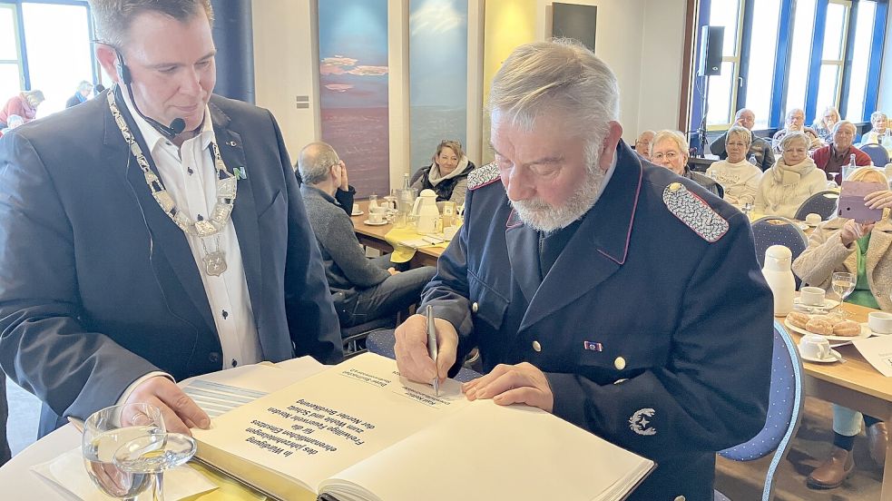 Ehrenbrandmeister Karl Kettler (rechts) wurde von Bürgermeister Florian Eiben auf besondere Weise geehrt: Er durfte sich ins Golde Buch der Stadt Norden eintragen. Foto: Rebecca Kresse