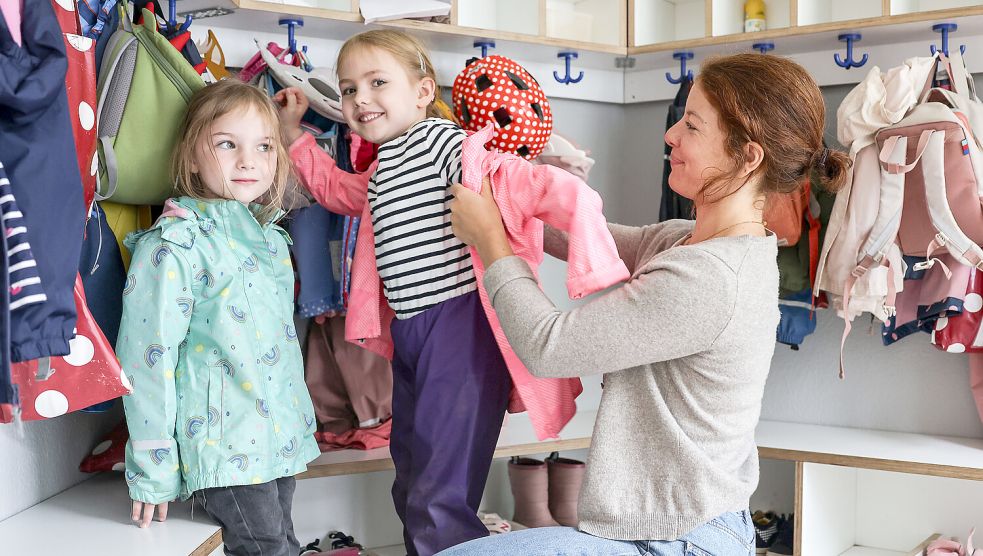 Eine Erzieherin hilft einem Mädchen in einer Kita beim Anziehen. Symbolfoto: Berg/dpa