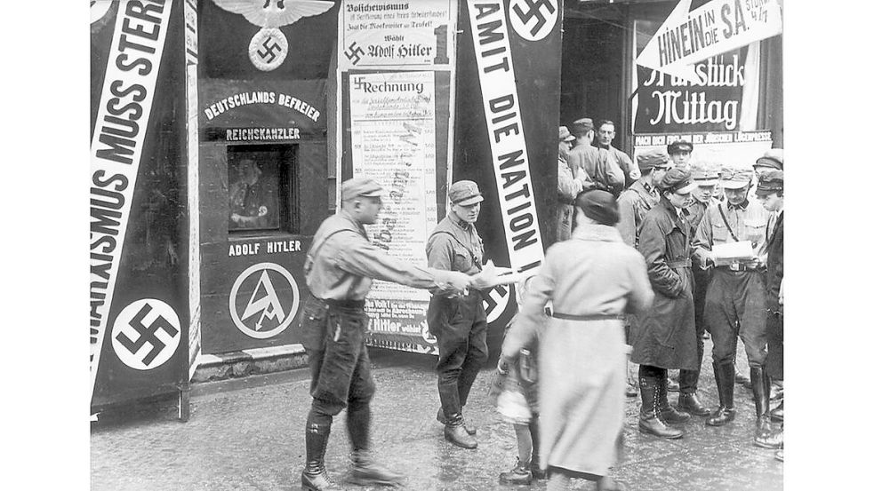 Mitglieder der NSDAP verteilen Flugblätter an Passanten. Bei der Wahl 1933 wurde die NSDAP stärkste Partei im deutschen Reich. Foto: Bildarchiv Preußischer Kulturbesitz