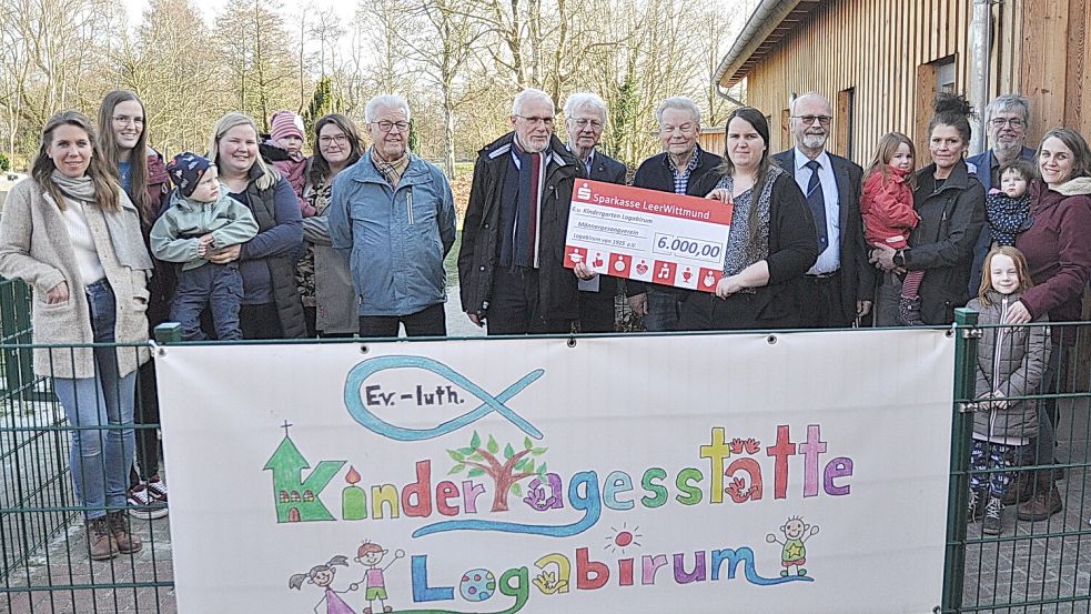 Des einen Leid ist des anderen Freud: Umringt von Eltern, Kindern, Sangesbrüdern und Kirchenvertretern überreichten die Vorstandsmitglieder des aufgelösten Männergesangvereins Logabirum (von links) Wübbo Oesten, Udo Hülsebus und Helmut Göbel ihr Restvermögen in Höhe von 6000 Euro an Kita-Leiterin Katrin Becker. Foto: Wolters