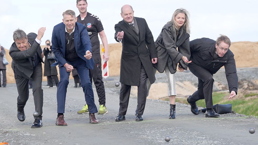 Bundeswirtschaftsminister Robert Habeck, Peter Carlsson (CEO von Northvolt), Christoph Vogler, (1. Vorsitzender des Boßelvereins Heid - Rüsdörp), Bundeskanzler Olaf Scholz, Botschafterin Veronika Wand-Danielsson und Schleswig-Holsteins Ministerpräsident Daniel Günther trafen sich zum Boßeln an der Baustelle in Dithmarschen. Foto: dpa/Marcus Brandt