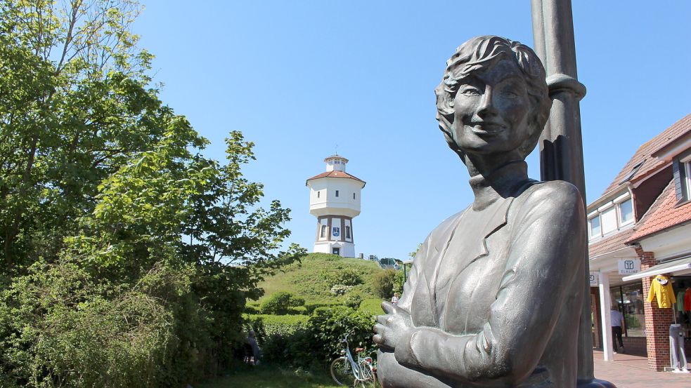 Zwei Langeooger Wahrzeichen auf einem Bild: Der Wasserturm und die der Insel sehr zugeneigte Sängerin Lale Andersen als Bronzefigur. Foto: Oltmanns