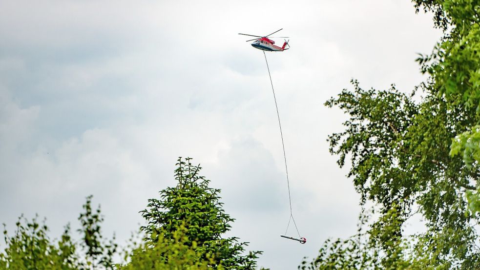 Dieser Hubschrauber ist derzeit über Ostfriesland zu sehen. Im Schlepptau hat er eine zehn Meter lange Elektromagnetik-Sonde. Foto: Ute Bruns.