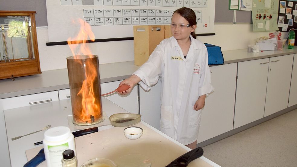 Grundschülerin Fiona Bredendiek gibt dem Feuer Nahrung: Sie „füttert“ ein kleines Flämmchen mit Sauerstoff.