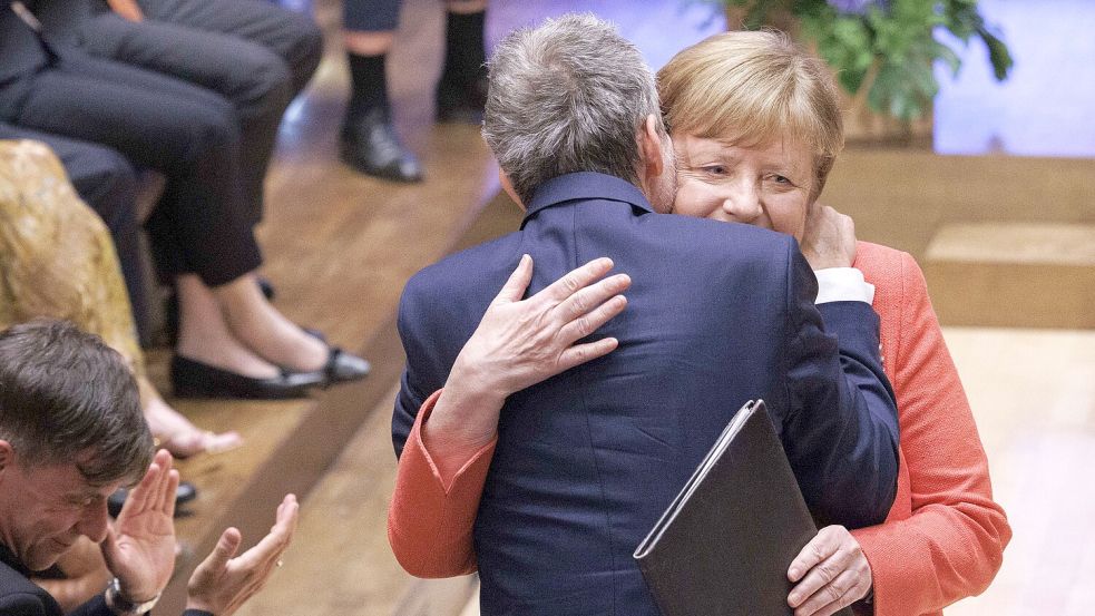 Innige Umarmung: Der Schauspieler Ulrich Matthes dankt Angela Merkel für ihre Rede. Beide erinnern an die Bedeutung von Empathie. Foto: Carsten Koall