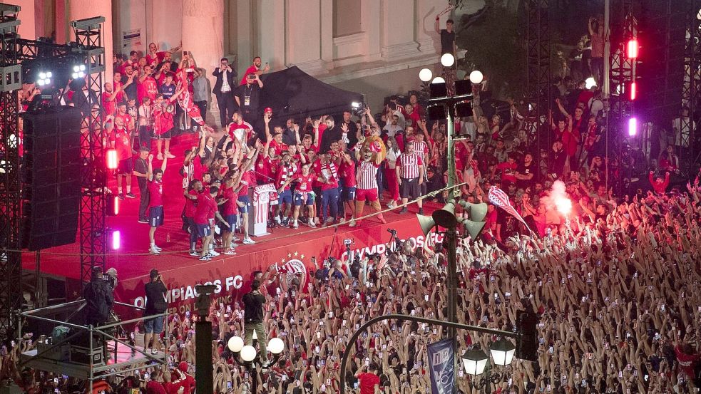 Die Spieler von Olympiakos Piräus feiern mit ihren Fans den Sieg im Conference-League-Finale. Foto: Michael Varaklas/AP