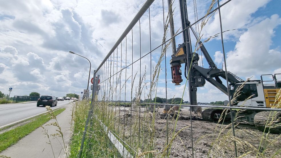 Während der Verkehr über die alte Ledabrücke rollt, wird auf der Baustelle daneben mit einer großen Maschine gebohrt. Foto: Bothe