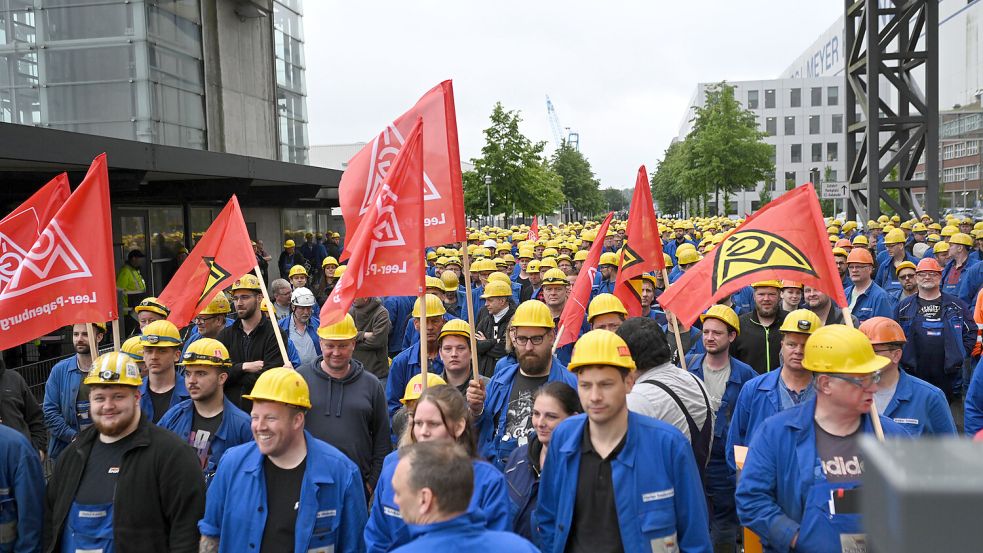 Mitarbeiter der Papenburger Meyer-Werft stehen unmittelbar nach der Betriebsversammlung am Mittwoch, 29. Mai 2024, zusammen. Foto: Lars Penning/dpa