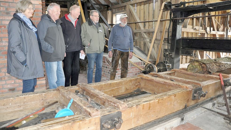 Kerstin Buss, Helmut von Aswege, Heyo Onken, Volkmar Ehmen und Anton Schoon schauen genau hin, wie die Gattersäge mit lautem „Ritsche-Ratsche" ihrer Arbeit nachgeht. Foto: Ullrich