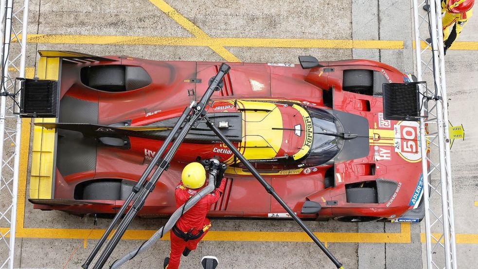 Mechaniker betanken das Auto des Teams Ferrari. Foto: Jeremias Gonzalez/AP/dpa