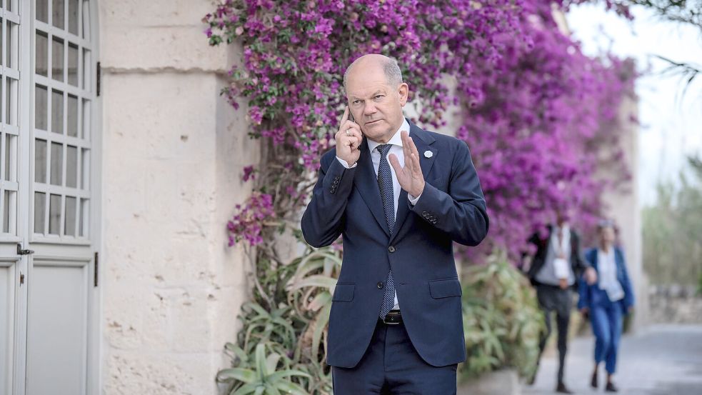 Bundeskanzler Olaf Scholz (SPD) telefoniert beim Gipfeltreffen der G7-Staaten. Foto: Michael Kappeler/dpa