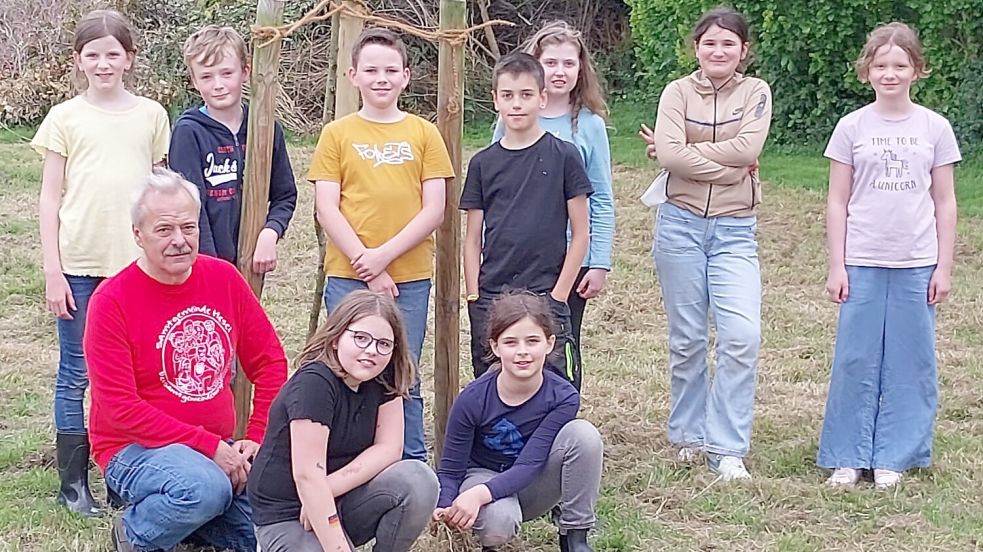 Die Kinder von der Zukunftswerkstatt der Grundschule Hesel hatten Samtgemeindebürgermeister Uwe Themann (vorne links) auf die neue Streuobstwiese eingeladen. Foto: Samtgemeinde Hesel