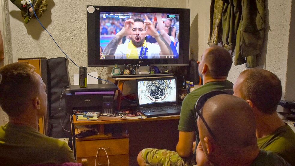 Ukrainische Soldaten schauen das EM-Spiel zwischen der Ukraine und der Slowakei. Selenskyj gratulierte dem Team zum 2:1-Sieg. Foto: Andriy Andriyenko/AP/Dpa