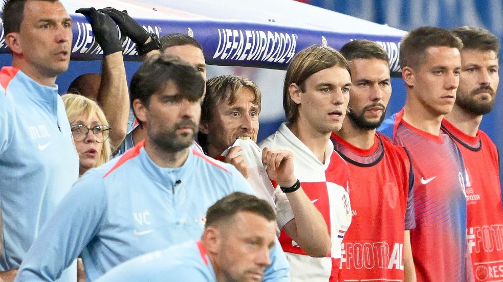 Kroatiens Luka Modric (M) und seine Teamkollegen schauen vom Spielfeldrand zu. Foto: Robert Michael/dpa