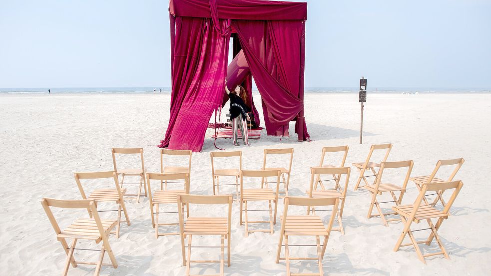 Vorhang auf: Der Strand ist die Theaterbühne für die Performance „Red Exit!“. Foto: Dittrich/dpa