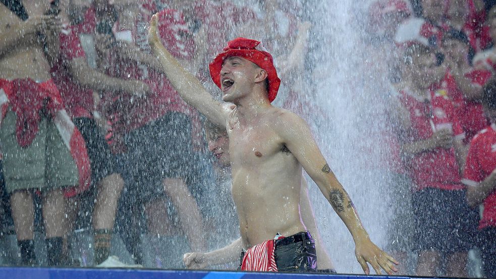Tanz unter dem Wasserfall. Ein dänischer Fan nimmt noch schnell eine Dusche. Foto: imago/Revierfoto