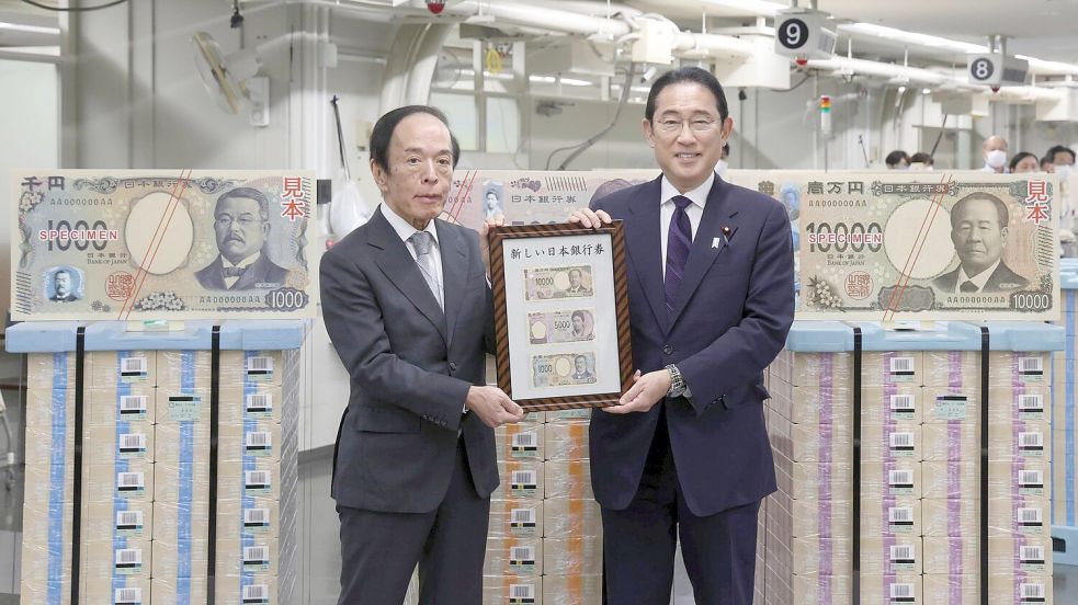 Japans Premierminister Fumio Kishida (r) und der Gouverneur der Bank of Japan, Kazuo Ueda, präsentieren die neuen Banknoten in Tokio. Foto: Uncredited/Japan Pool via Kyodo News/dpa