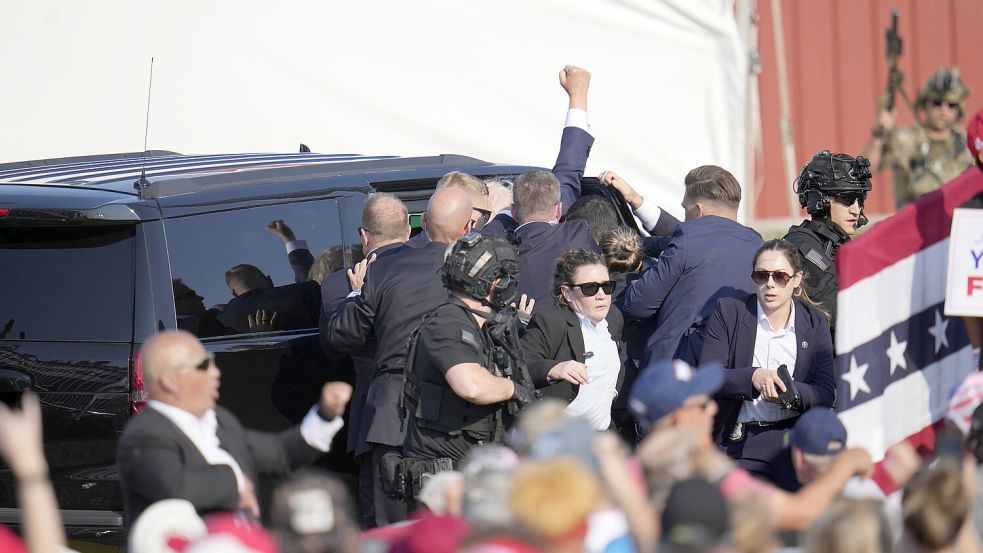 Der republikanische Präsidentschaftsbewerber und ehemalige Präsident Donald Trump bei einer Wahlkampfveranstaltung in Butler von der Bühne in ein Fahrzeug geholfen. Foto: dpa/AP