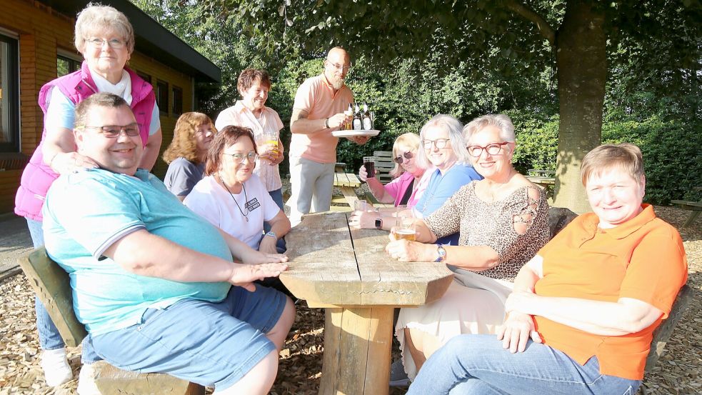 Plötzlich kommt die Sonne raus und Lüttje-Haven-Betreiber Stefan Budde kann draußen servieren: der Freizeittreff Wiesmoor beim letzten Treffen am Ottermeer. Links steht Brigitte Maune hinter ihrem Mann Axel. Foto: Böning