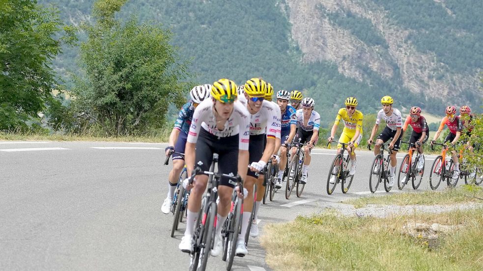 Tadej Pogacar (M) auf der 19. Etappe der 111. Tour de France. Foto: Jerome Delay/AP/dpa