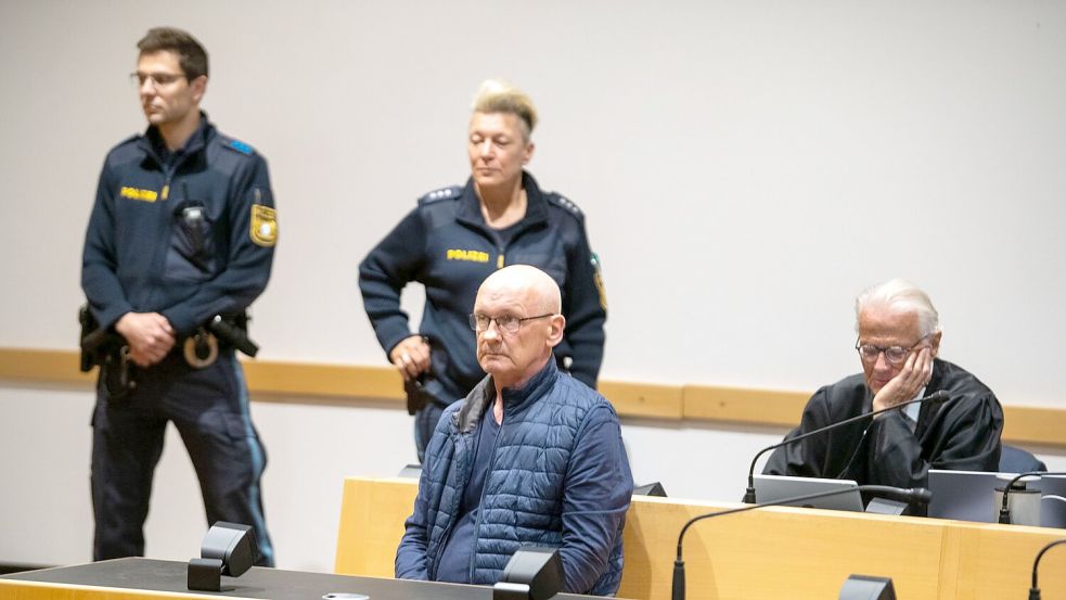 Der wegen der Ermordung von drei Nachbarn angeklagte Mann wird im Gerichtssaal von Polizisten bewacht. Der Mann will nach Angaben seines Anwalts auf Bildern nicht unkenntlich gemacht werden. (Archivfoto) Foto: Stefan Puchner/dpa