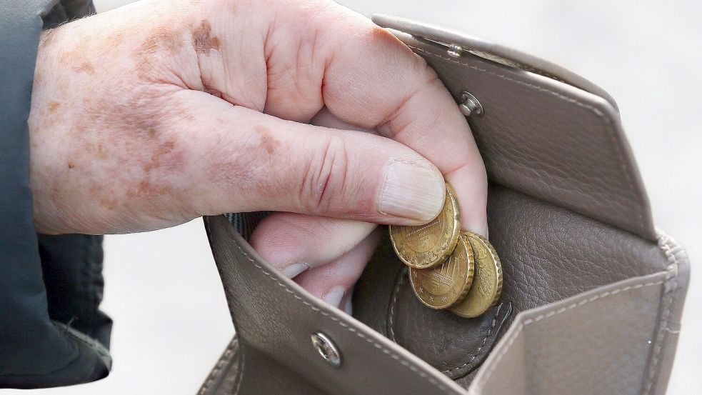 Eine Frau holt Münzen aus ihrem Portemonnaie. Der Bezug von Grundsicherung lässt Rückschlüsse auf die Entwicklung von Altersarmut zu. Foto: DPA