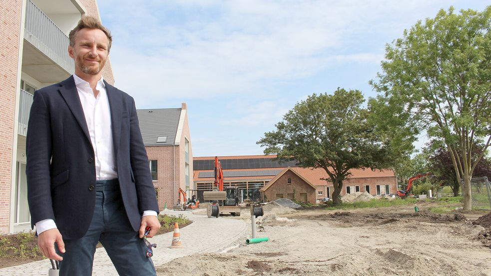 Konrad Lüders vor dem Hotel „Noord“ in Carolinensiel eine Woche vor der Eröffnung. Im Hintergrund ist der alte Gulfhof zu sehen. Er ist Teil der neuen Hotelanlage. Foto: Oltmanns