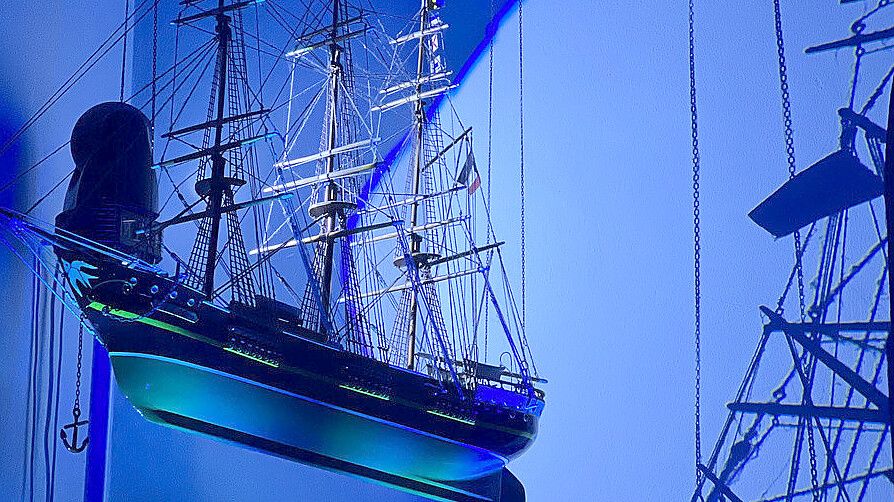 Das Künstlerduo „Scheinzeitmenschen“ setzt das Modellschiff „Ora Et Labora“ in der evangelischen Nikolai-Kirche Wangerooge in Szene. Foto: Kirche am Meer Wangerooge