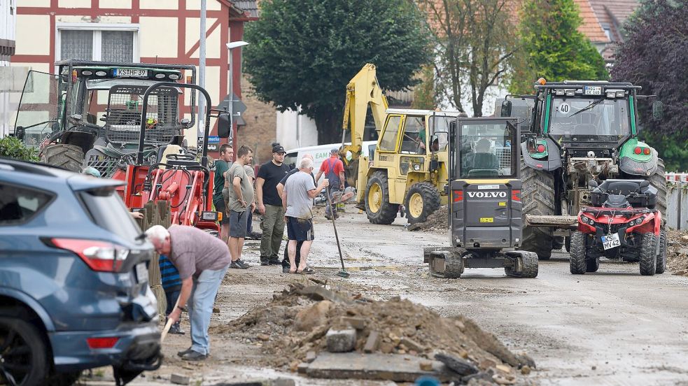 Helfer sind nach dem Unwetter in dem Trendelburger Stadtteil Gottsbüren im Einsatz. Foto: Swen Pförtner/dpa