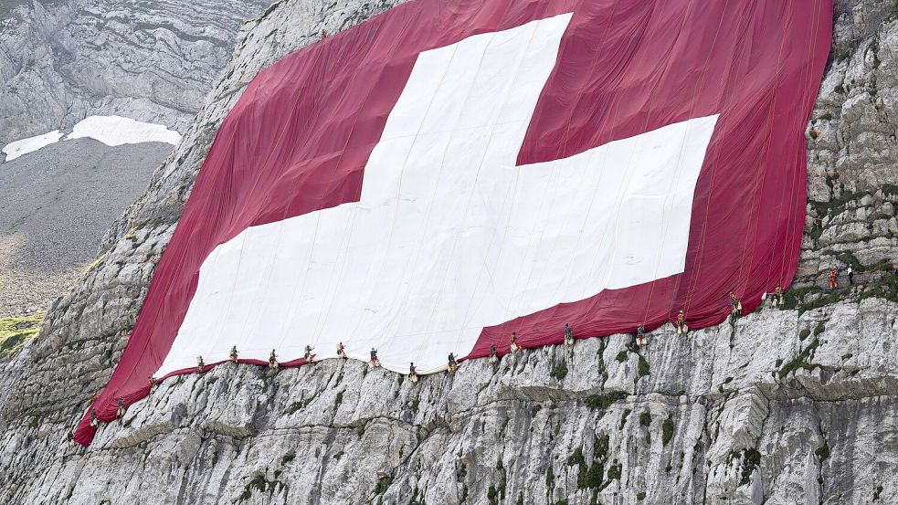 Anfang August wird am Säntis eine riesige Schweizerfahne zum Nationalfeiertag angebracht und danach wieder abgebaut. Höhenarbeiter beteiligten sich am Rettungseinsatz. Foto: Gian Ehrenzeller/KEYSTONE/dpa