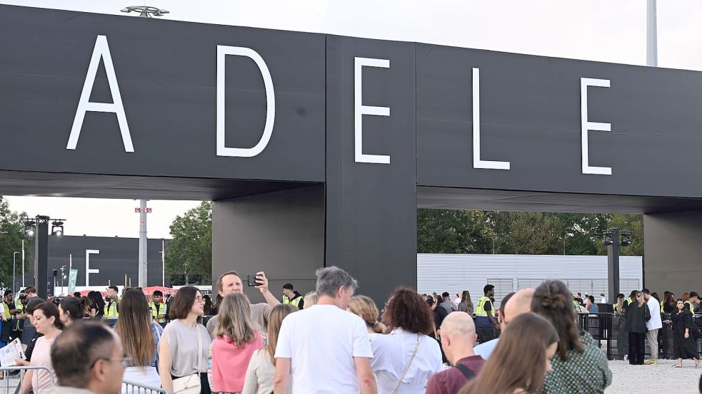 Besucher sind auf dem Weg zu einem Konzert der britischen Sängerin Adele. Foto: Felix Hörhager/dpa