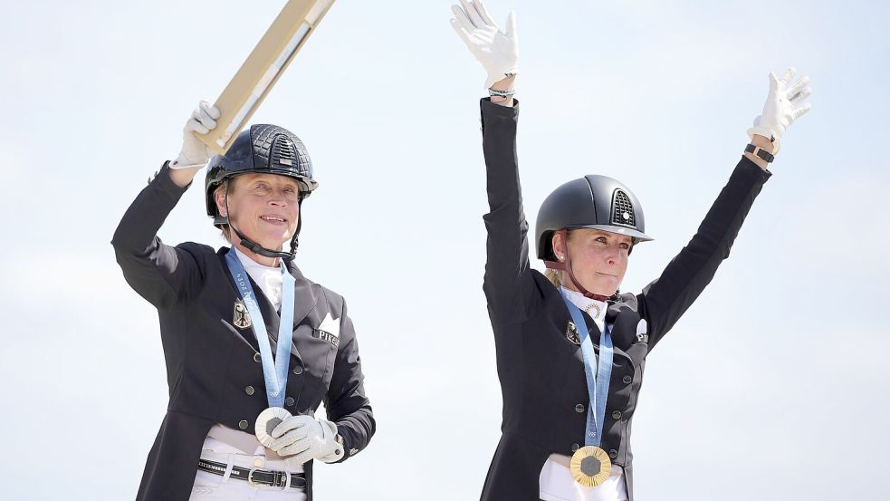 Jessica von Bredow-Werndl und Isabell Werth feiern ihre Medaillen. Foto: Rolf Vennenbernd/dpa