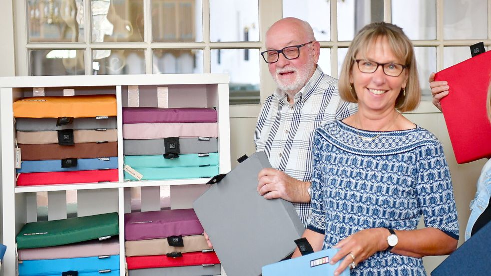 Der Kirchenratsvorsitzende von Rysum, Hartwig Peters, und Kirchenratsmitglied Elke van Hoorn schauen sich die neuen Sitzkissen genauer an. Fotos: Wagenaar