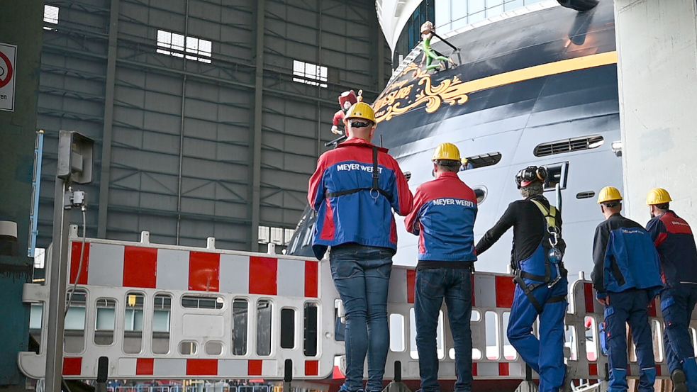 Großes Ereignis am Samstag in Papenburg: Mitarbeiter der Meyer Werft beobachten das Ausdocken des Kreuzfahrtschiffs „Disney Treasure“. Foto: Penning/DPA