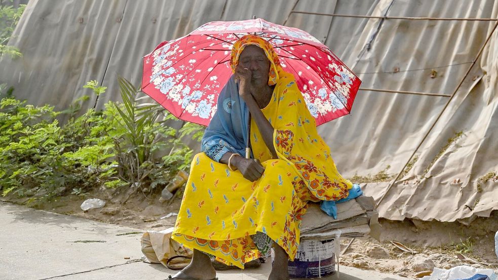 Diese Frau in der Elfenbeinküste schützt sich vor Hitze. Global gesehen war es im Juli wieder außergewöhnlich warm. (Archivbild) Foto: Britta Pedersen/dpa