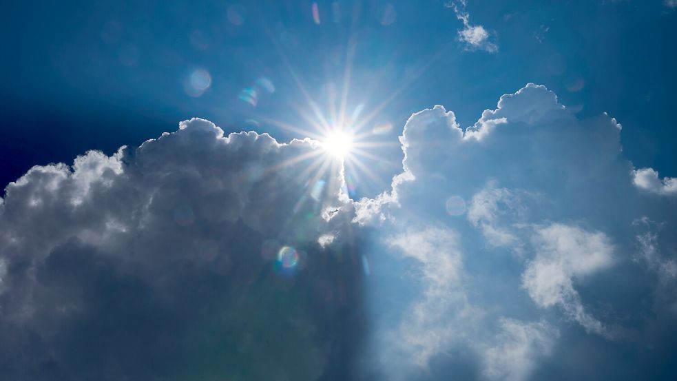 Die Sonne scheint am Rand von dunklen Wolken. Symbolfoto: Annette Riedl/dpa